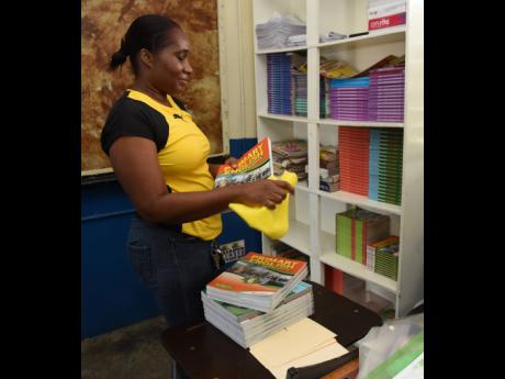 Credit: Ian Allen Shernet Thompson, grade six teacher at Clan Carthy Primary School in Kingston, cleans books before filing them in her classroom days before the reopening of school in September.