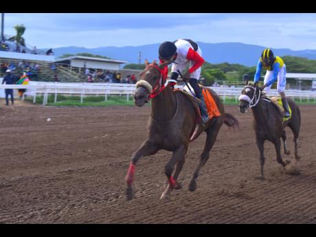 
MONEY MISER (left), ridden by Tevin Foster, wins the O & S Tack Room Trophy Division I over a mile at Caymanas Park yesterday.