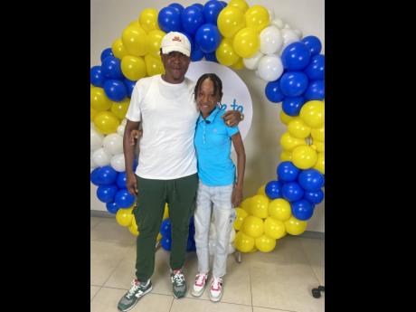 Credit: Ainsworth Morris photo Up-and-coming track and field star, Alzeliha Allen (right), is embraced by her father, Anthony Allen, after she was announced as a Courts Dare to Dream scholarship awardee on Friday at the stores’ corporate offices in Kingston.