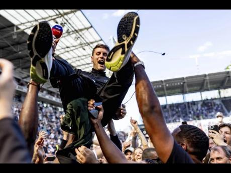 Credit: AP Fabian Hurzeler is lifted by fans who invaded the field after their team FC St Pauli won 3-1 during a second division, Bundesliga match against VfL Osnabrueck, at the Millerntor Stadium, in Hamburg, Germany, on May 12, 2024.