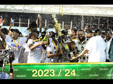 Cavalier Soccer Club members celebrate victory as they are presented with the 2023-24 Jamaica Premier League Trophy after defeating Mount Pleasant Academy in the final at the National Stadium last season.