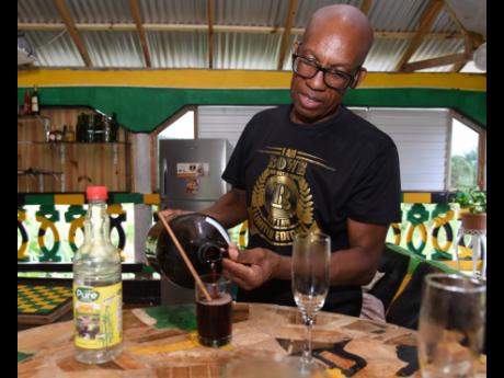 Credit: Ian Allen/Photographer Dr Lennox Rowe, founder of Rowe’s Wine in Ballards Valley, St Elizabeth, pours red wine for tasting.