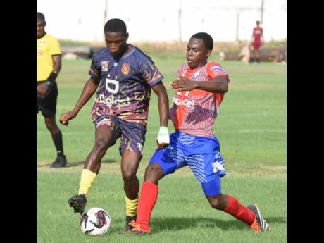 Dwayne Atkinson (left) of St Andrew Technical dribbles past Hughdean Sutherland of Camperdown High during their Zone D ISSA Manning Cup football match at Boys’ Town on Wednesday. St Andrew Technical won 2-0.