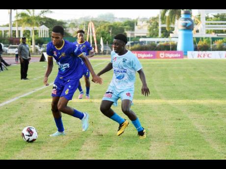 Clarendon College’s Dante Walters (left) tries to get away from Denbigh High’s Odaine Thompson during the opening match of the ISSA/WATA daCosta Cup football competition at the Montego Bay Sports Complex on Saturday, September 7. 