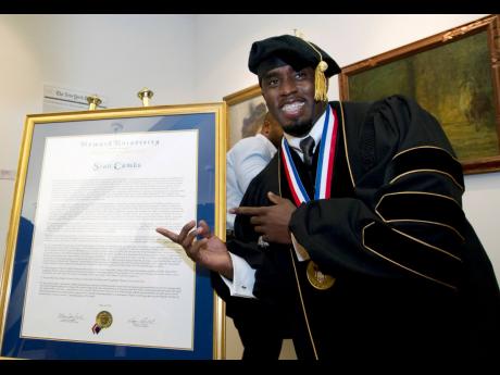 FILE - Entertainer and entrepreneur Sean Combs poses next to his honorary degree of Doctor of Humanities during the graduation ceremony at Howard University in Washington, Saturday, May 10, 2014. In a decision, Friday, June 7, 2024, Howard University cut t