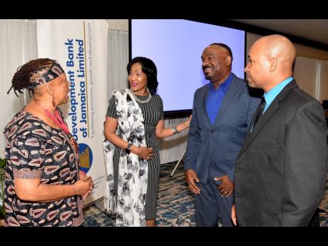 General Manager in the Strategic Services Division at Development Bank of Jamaica (DBJ), Deborah Newland (second left), introduces General Manager for Trade & Commercial Lending at EXIM Bank, Winston Lawson (second right), to founder and artistic director 