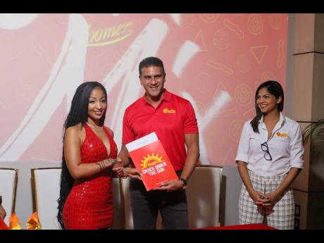 Shenseea (left) collects a copy of her ambassador contract from Nicholas Jack, deputy chairman and group chief executive officer of Associated Brands Industries Limited, after the signing ceremony on Wednesday, with Kathryn Inniss, general manager of Sunsh