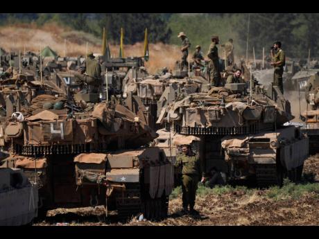 Israeli soldiers work on tanks in northern Israel on Friday, September 27.