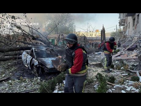 In this photo provided by the Ukrainian Emergency Service, emergency workers clear the rubble after Russia attacked the city with guided bombs overnight in Zaporizhzhia.