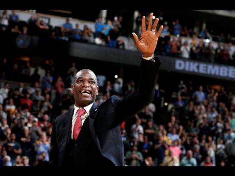 Retired Denver Nuggets centre Dikembe Mutombo waves to the crowd as his jersey number was retired by the team during halftime of the Nuggets’ NBA basketball game against the Portland Trail Blazers on Saturday, October 29, 2016, in Denver. 