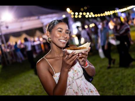 Entrepreneur and ‘Karnival Kween’, Kandi King, goes in for a bite of the lobster fritters from Jabba’s Seafood and Grill. 