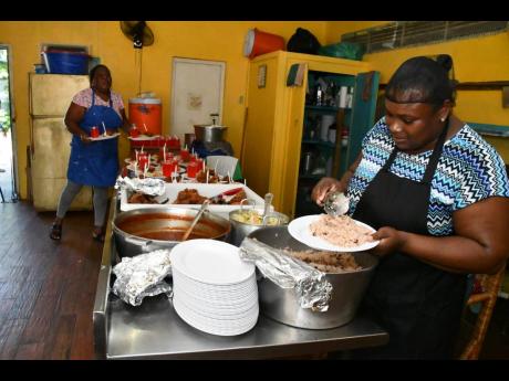 Credit: Contributed Photos Volunteers at St Anthony’s Kitchen in Negril, Westmoreland, Andrea Myles (left) and Georgia Myrie, prepare to serve lunch to the needy in Negril.