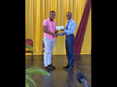 Throne Moxam (left), BOOST fellow, receiving his ‘Best Form Teacher’ award from Dwight Pennycooke, principal of Wolmer’s Boys’ School.
