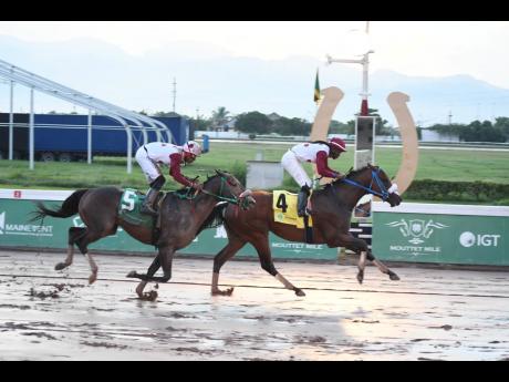 Anthony Minott/Freelance Photographer 
FUNCAANDUN (right), ridden by Robert Halledeen, wins the seven furlong, three-year-old and upwards open allowance graded stakes Phillip Feanny OD Gold Cup ahead of IS THAT A FACT (Tevin Foster) at Caymanas Park yester