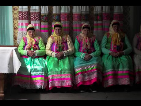 Women in traditional Doukhobor dresses pray at the former Orphanage house where Doukhobors has worshiped for years, on Easter in the remote mountain village of Gorelovka, Georgia.