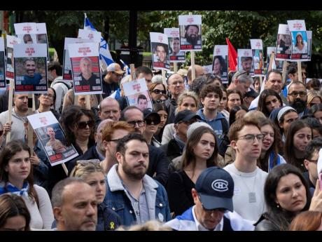 People hold pictures of hostages as they attend a pro-Israel vigil on the anniversary of a Hamas attack on Israel that triggered the ongoing war in Gaza in front of McGill University in Montreal, Canada on Monday.