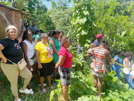 Credit: Photo by Andre Williams Residents watch as investigators visit the crime scene.