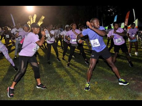 Participants in the CIBC Caribbean’s Walk for the Cure Run/Walk, warm up before the start of the event.  
