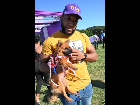 Javaun Powell holds his dog, Chanel, a Pomeranian mixed with Shih Tzu, who was all dolled up for the expo in a strawberry dress.