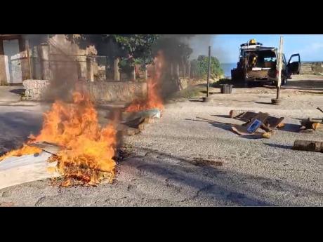 A fire that was lit by protesting residents in Sandy Bay, Hanover, along the Montego Bay to Negril thoroughfare.
