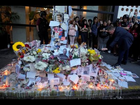 Geoff Payne, right, the father of former One Direction singer Liam Payne, visits a memorial dedicated to his son outside the Casa Sur Hotel, where the British pop singer fell to his death from the hotel balcony, in Buenos Aires, Argentina. 
