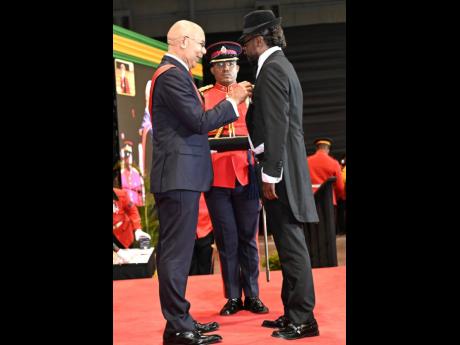 Credit: Rudolph Brown Governor General Sir Patrick Allen, presents the Order of Distinction in the rank of Officer to Moses ‘Beenie Man’ Davis at the National Honours and Awards Investiture Ceremony at the National Indoor Sports Centre.
