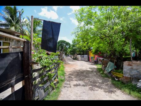 A black flag on a fence is a grim reminder of the mass shooting which took place on Sunday, August 11 in Cherry Tree Lane, Clarendon.