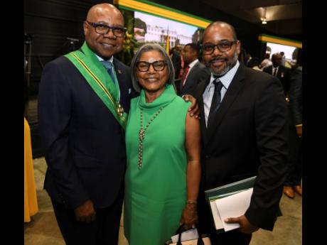 Edmund Bartlett, minister of tourism (left), shares a moment with his wife, Carmen Bartlett (centre), and son, Edmund Bartlett Jr. Bartlett was conferred with membership in the Order of Jamaica. 