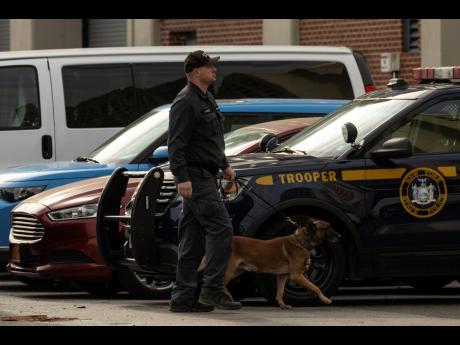 Credit: AP A police officer with a K-9 is seen outside the Metropolitan Detention Center during an interagency operation, Monday, in the Brooklyn Borough of New York.