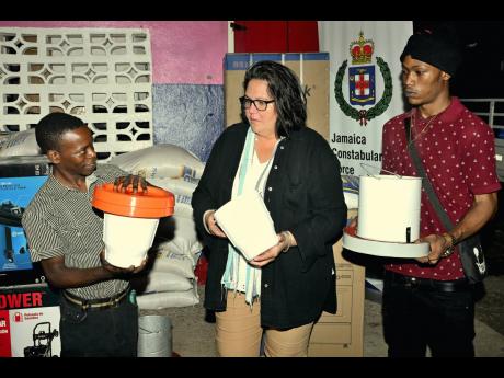Saffrey Brown (centre), director of Project STAR, presents equipment to Cloyous Lewin (left) and Geovaughn Kiffin, participants in Project STAR’s Nano-Programme.