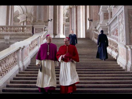 This image released by Focus Features shows Brían F. O’Byrne (left) and Ralph Fiennes in a scene from ‘Conclave’.  