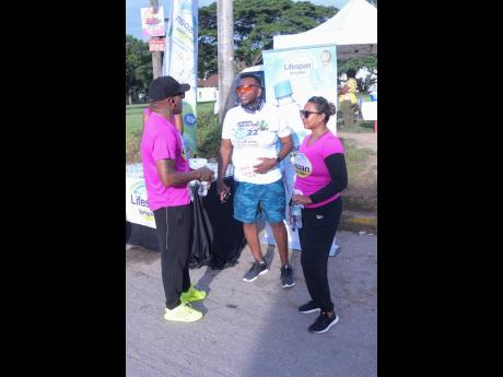 Student Kurt McKenzie chats with Olaf Blackwood (right) Lifespan Ambassador and Nayana Williams CEO Lifespan at the UWI Guild Pink Run on Saturday.