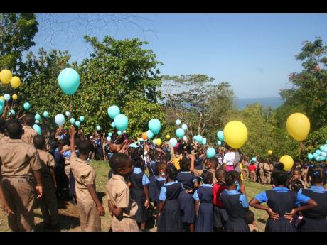 Students of Bethel Primary and Bethel Infant Schools, accompanied by teachers and staff, release balloons that represent negativity.