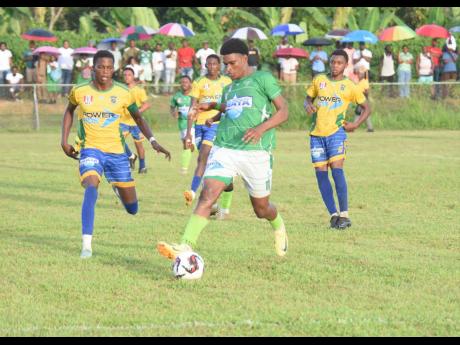 Credit: Ashley Anguin Frome Technical High School’s Stevaughn Spence (centre) gets to a ball during an ISSA/WATA daCosta Cup encounter against Rusea’s at the Collin Miller Sports Complex in Lucea on Wednesday, October 9.
