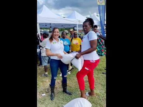 Ann-Marie Vaz (left), member of parliament for East Portland, makes a presentation to a farmer from the constituency. 