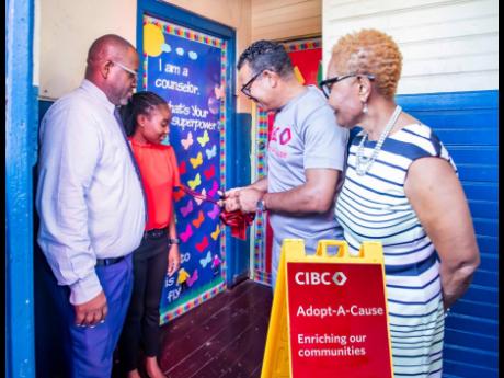 Credit: Contributed Photos Nigel Holness (second right), managing director, CIBC Caribbean, cuts the ribbon to the newly refurbished library at Franklin Town Primary School on October 25. Looking on (from left) are Rohan Trevleven, principal; Shandona Burton, guidance counsellor; an