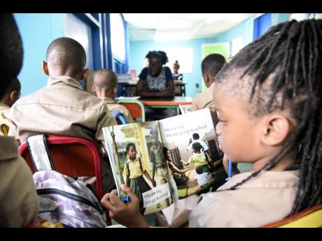 In this file photo, students of Grove Primary School are seen reading books. Gleaner Editorial writes: This crisis demands immediate and aggressive intervention, including ... a mobilisation to reading and writing equivalent to that of the 1970s campaign f