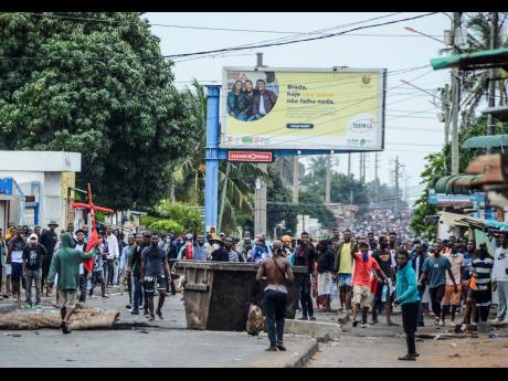 Protesters fill the street as police deploy in Maputo, Mozambique, on Thursday.