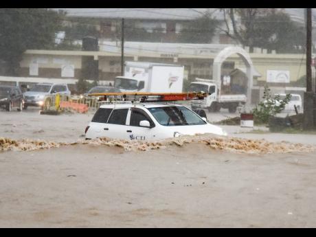 In this 2021 photo, a car is seen submerged in a flooded road in 7 Mile, Bull Bay. 