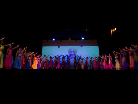 Dancers from several companies filled the stage as their tribute to Tony Wilson closed on Friday night. They are pointing to Wilson’s picture.