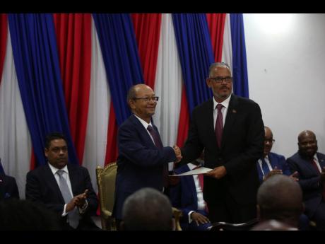 Haiti’s new Prime Minister Alix Didier Fils-Aimé (right) shakes hands with Transition Council President Leslie Voltaire during his swearing-in ceremony in Port-au-Prince, Haiti, on Monday, November. 11, 2024.