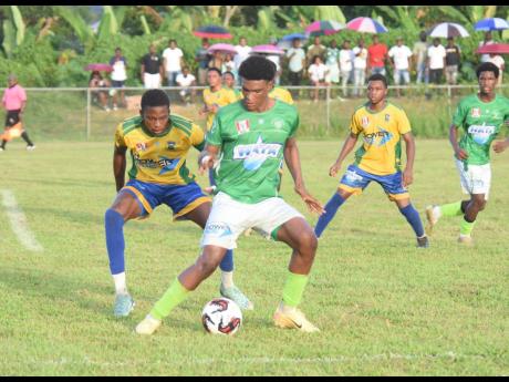 Frome Technical’s Stevaughn Spence (right) keeps the ball away from Rusea’s High School’s Andre Brown during their ISSA/WATA daCosta Cup football match at the Collin Miller Sports Complex in Lucea on October 9.
