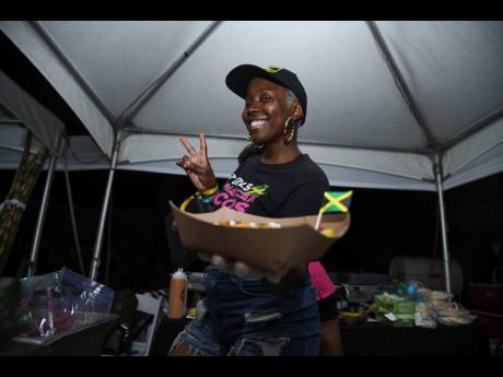 Chef Shelly Flash, founder and chief executive officer of 2 Girls and a Cookshop, shows off the jerk birria with jerk consommé taco at Saturday’s Meet Street event. 