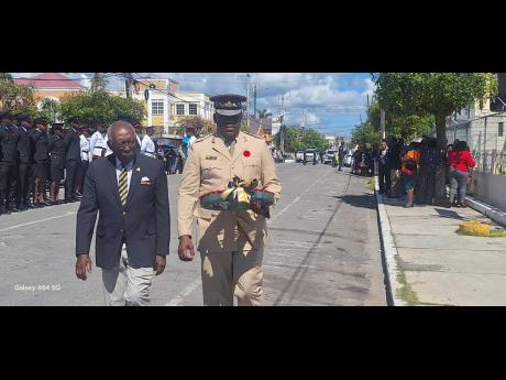 World War II veteran Leslie Dawkins, 98, is escorted by Captain Keffa Davis, of the Jamaica Combined Cadet Force, towards the Cenotaph in Norman Square, Savanna-la-Mar, Westmoreland, on November 11. 