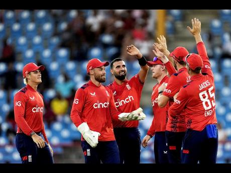 Credit: AP England’s Saqib Mahmood (centre) celebrates with teammates after taking the wicket of West Indies’ Roston Chase during the third T20I cricket match at Daren Sammy National Cricket Stadium in Gros Islet, St Lucia, yesterday.