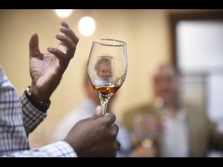 In this 2018 photo, an image is reflected in a glass with Appleton rum during the launch of the Joy Spence Appleton Rum Tour Experience.