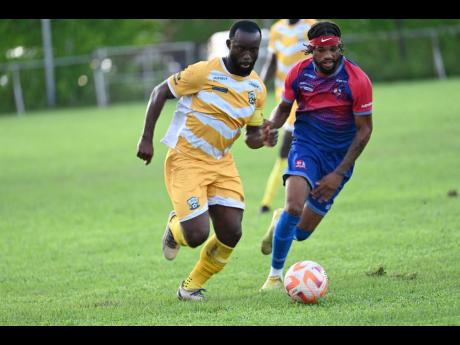 Molynes United’s Jason Wright (left) dribbles by Dunbeholden’s Chevoy Watkin during their Jamaica Premier League contest at the Waterhouse Stadium in Drewsland yesterday.