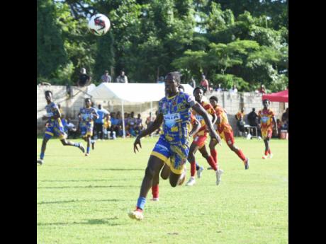 St Elizabeth Technical High School's Justin McPherson chases a ball during his side's ISSA/WATA Ben Francis Cup quarterfinal game against Cornwall College at the Llandilo Sports Complex in Westmoreland yesterday.