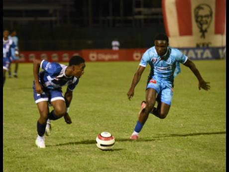Jamaica College’s Jabarie Howell (left), takes a peek inside while being chased by McGrath’s David Hutchinson during their Champions Cup quarterfinal game at the Montego Bay Sports Complex last night.
