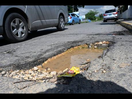 
A motorist dodging a pothole on Elletson Road in Kingston.